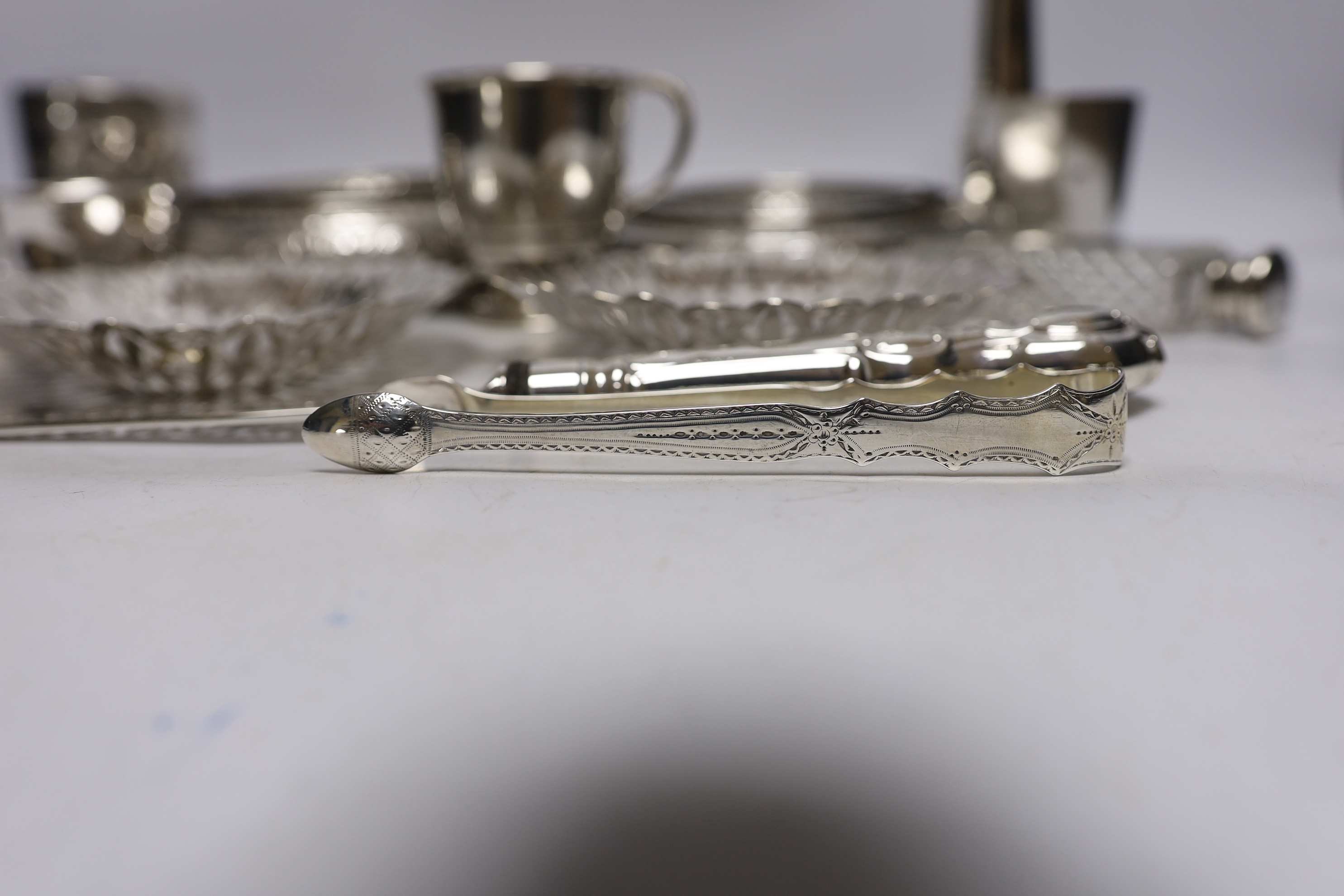 A group of silver and a white metal items including two Middle Eastern ring vases, two foliate dishes, a vase and a canister, together with a silver christening mug, 800 standard beaker, silver fish slice, two mounted gl